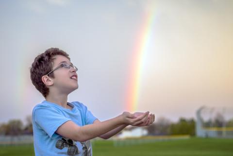 Awestruck child catching rainbow