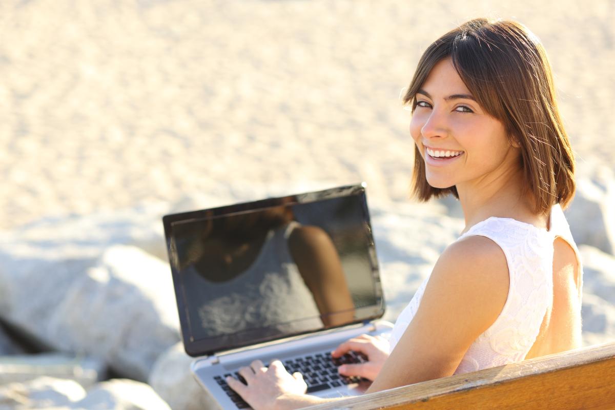 Girl with laptop on beach