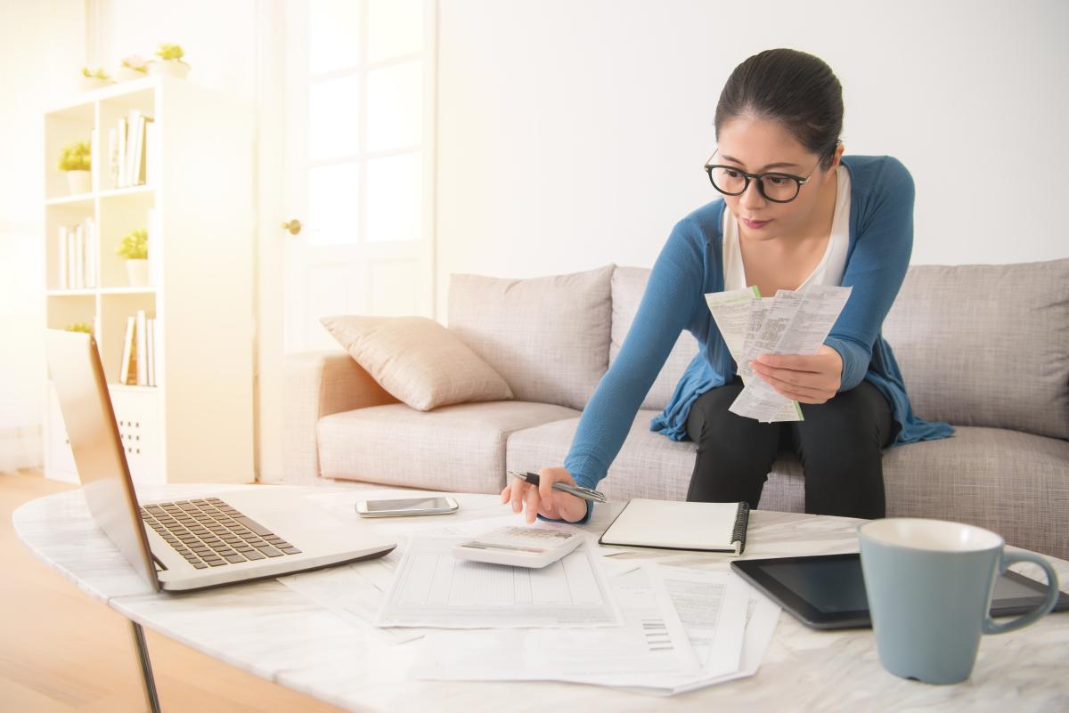 woman and computer with pen and paper calculating