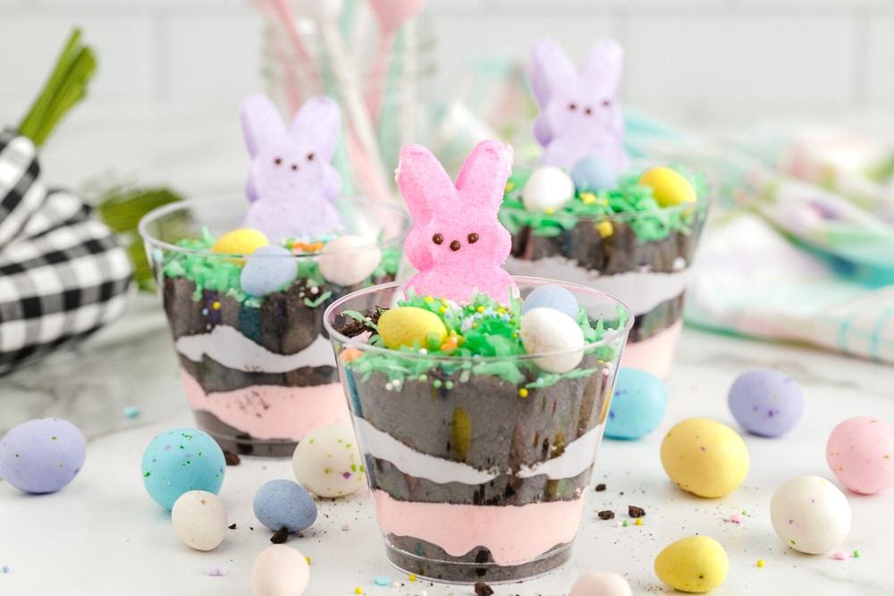 Pudding cups decorated with green coconut, candy eggs, and marshmallow bunnies.