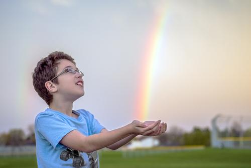 Awestruck child catching rainbow