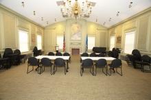 image of memorial room showing two columns of rectangular tables with chairs on one side of each table, resembling a classroom setup
