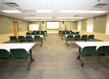image of rotary room showing two columns of rectangular tables with chairs on one side of each table, resembling a classroom setup